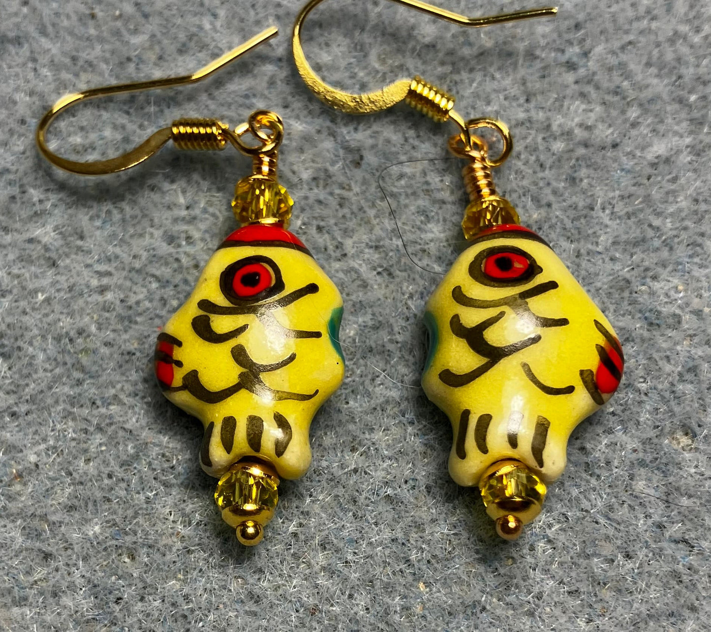 Small yellow, black, and red ceramic fish bead earrings adorned with yellow Chinese crystal beads.