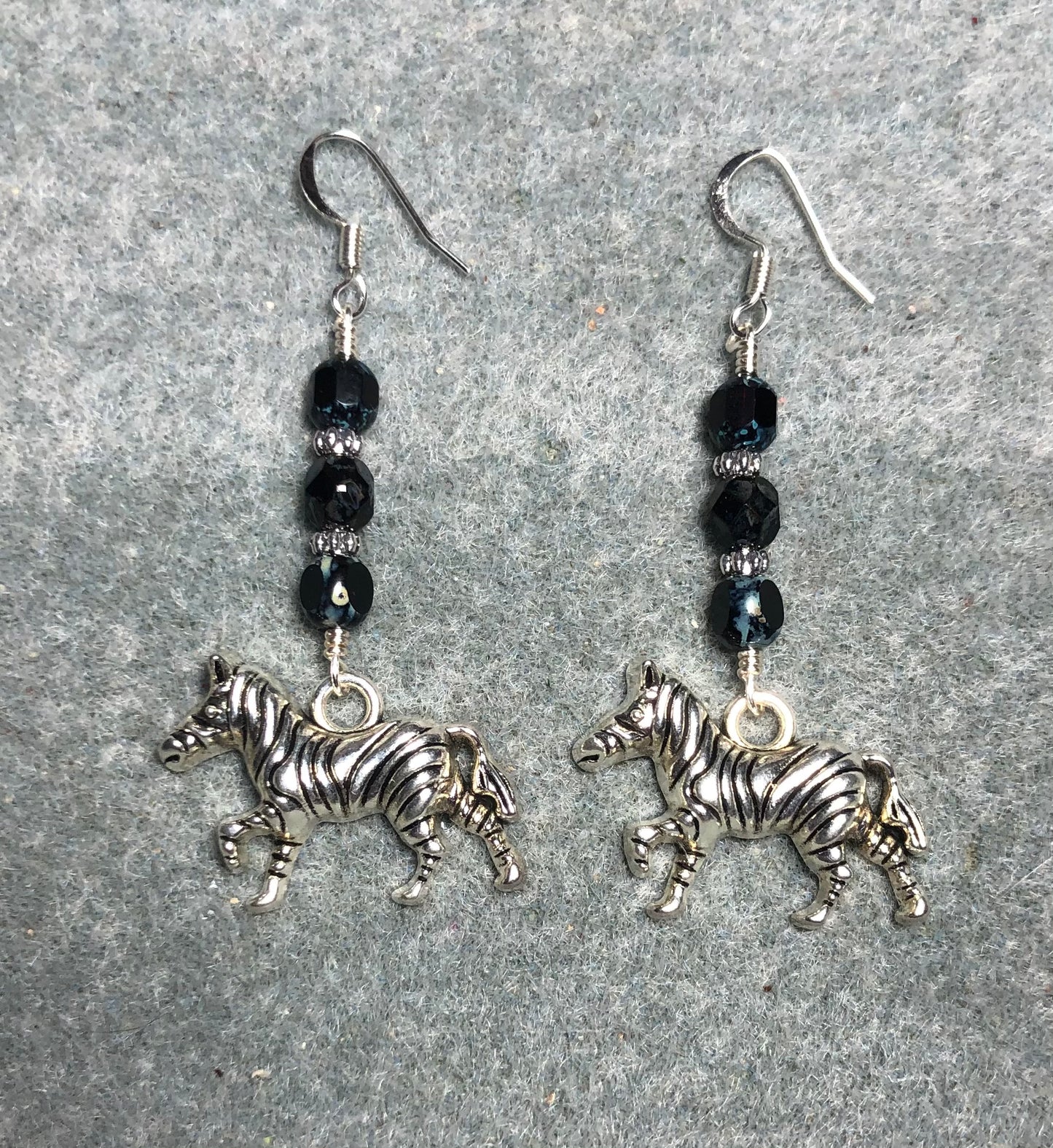 Silver zebra charm earrings adorned with black Czech glass beads.