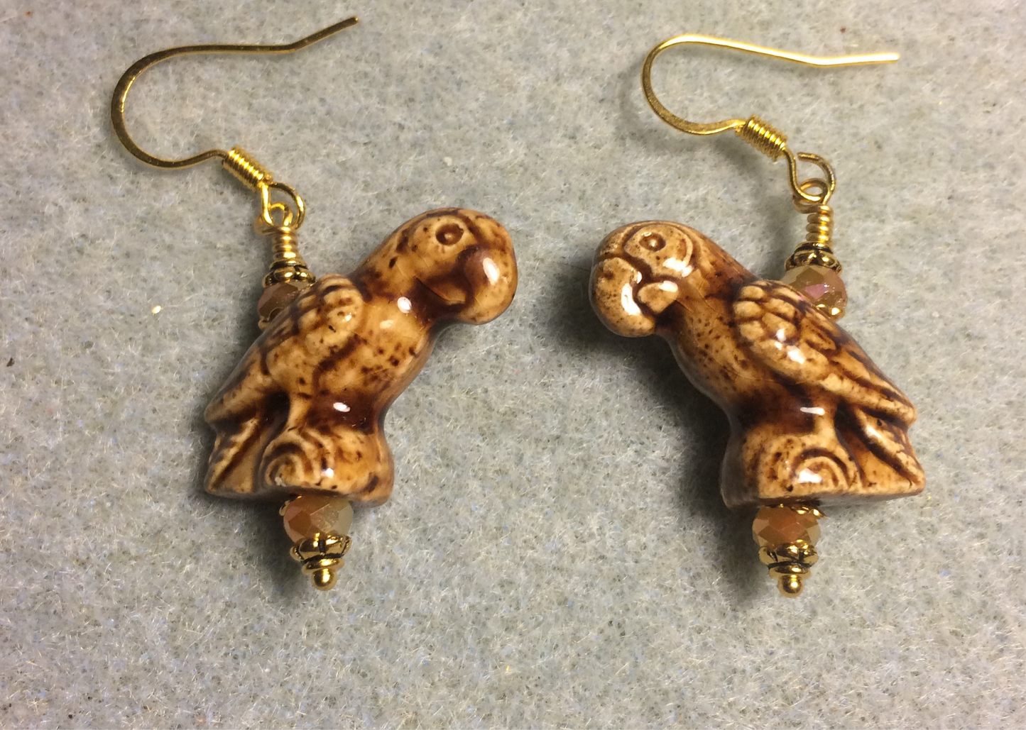 Brown ceramic parrot bead earrings adorned with tan Chinese crystal beads.