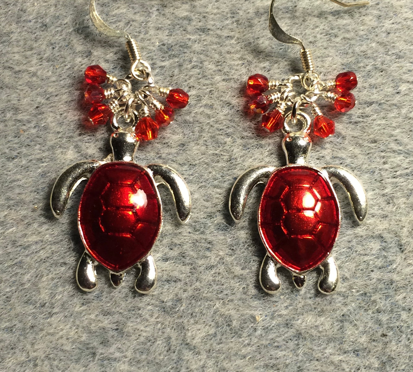 Bright red enamel sea turtle charm earrings adorned with small dangling red Czech glass beads.