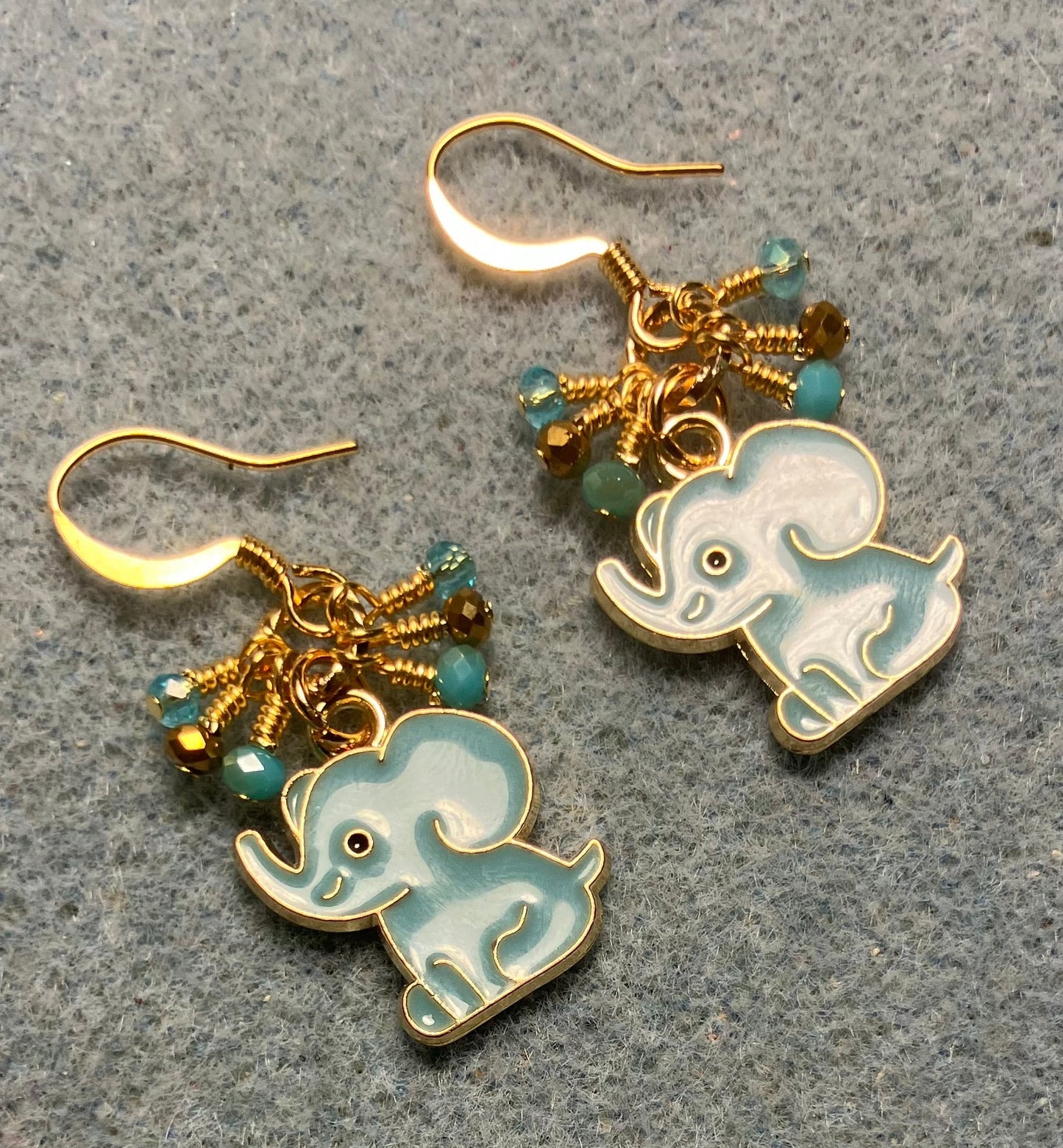 Aqua and gold enamel elephant charm earrings adorned with tiny dangling aqua and gold Chinese crystal beads.