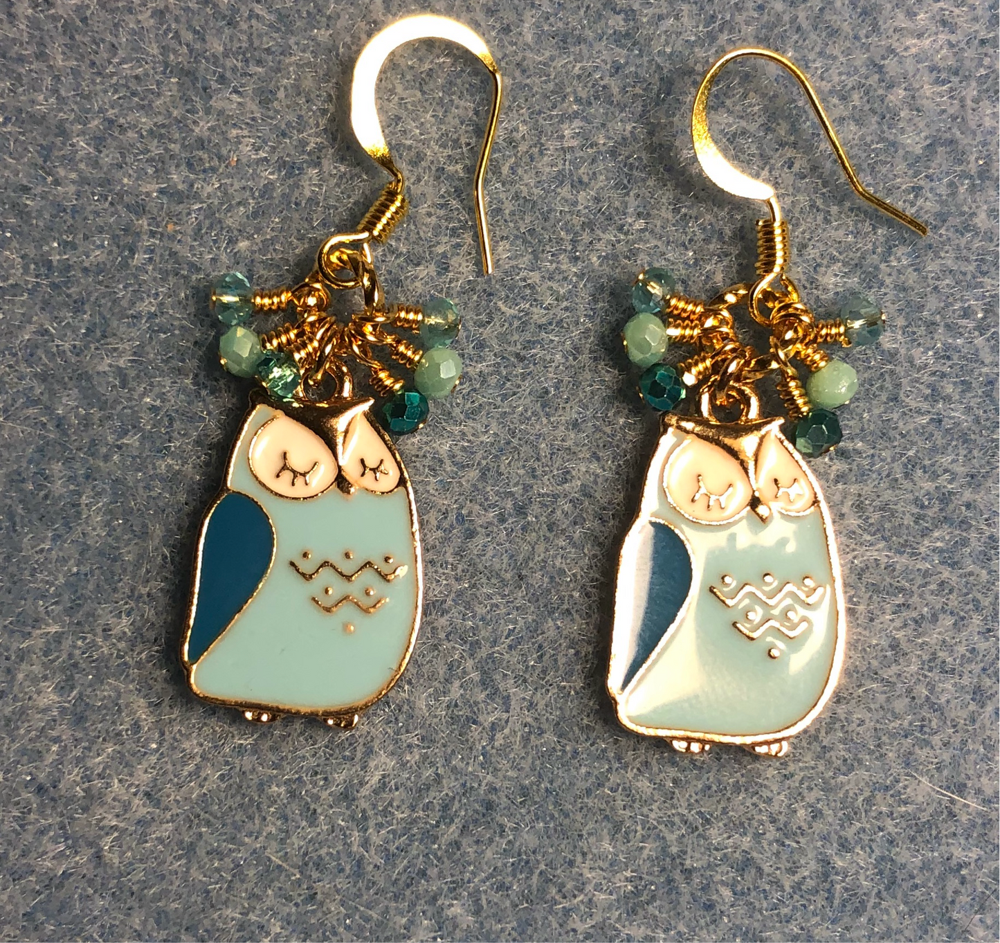 Aqua, turquoise, and white enamel sleepy owl charm earrings adorned with tiny dangling aqua and turquoise Chinese crystal beads.