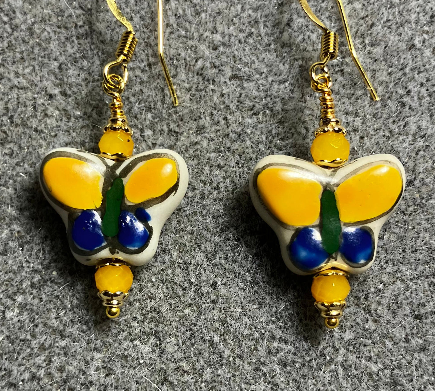 Dark blue and yellow ceramic butterfly bead earrings adorned with yellow Chinese crystal beads.