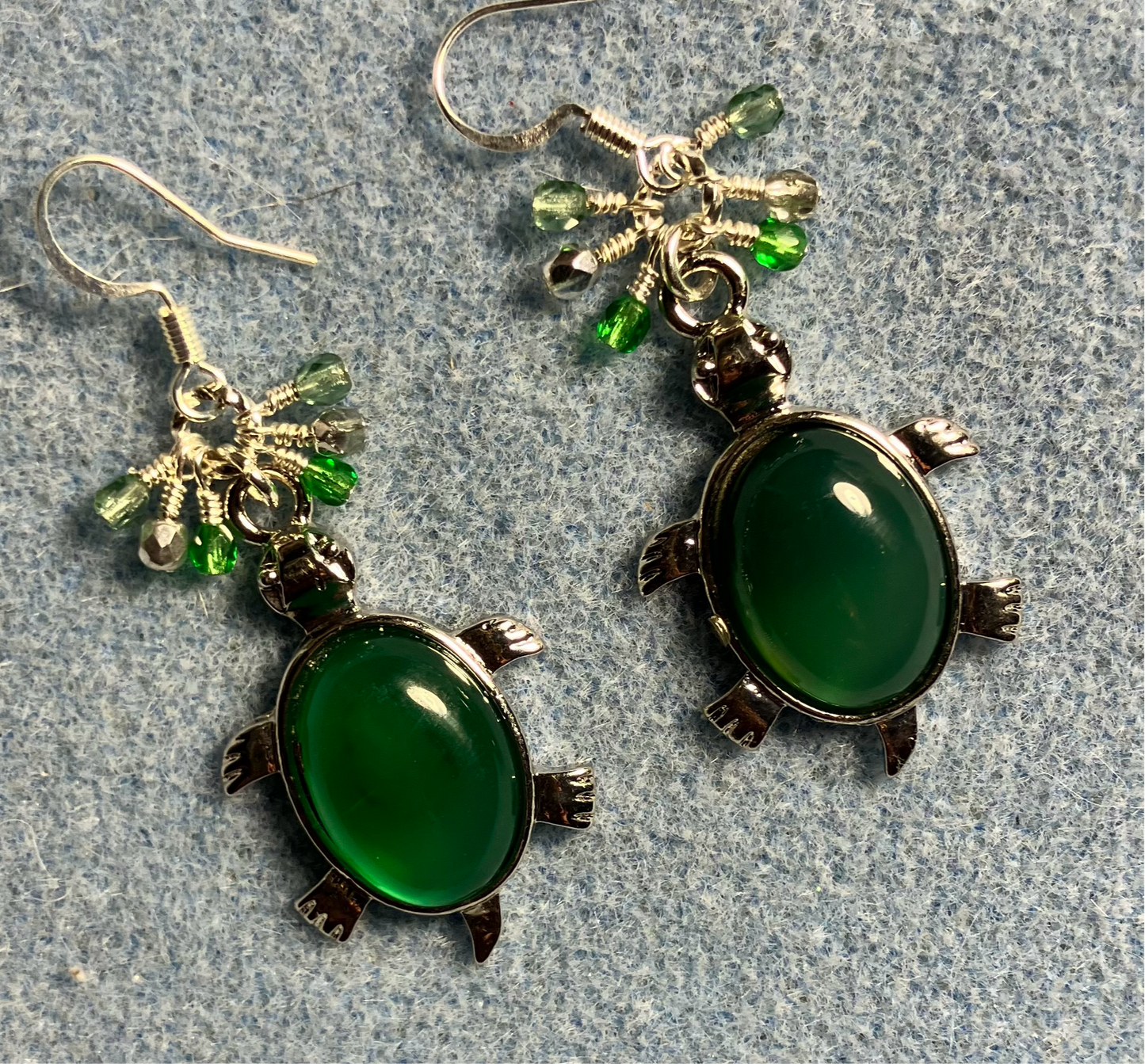 Large silver and green agate gemstone turtle charm earrings adorned with small dangling green and silver Czech glass beads.