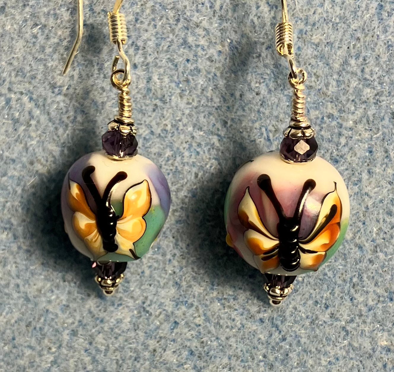 Purple and tan lamp work butterfly bead earrings adorned with purple Chinese crystal beads.