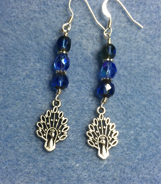 Silver peacock charm earrings adorned with blue Czech glass beads