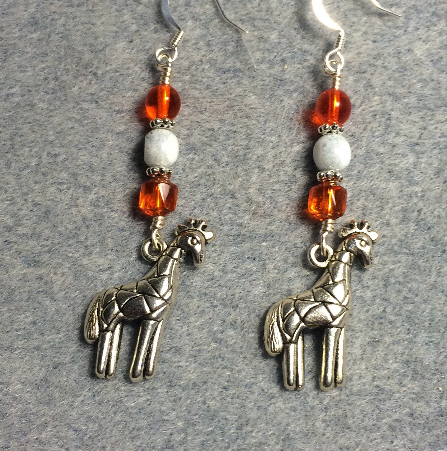 Silver giraffe charm earrings adorned with orange and white Czech glass beads