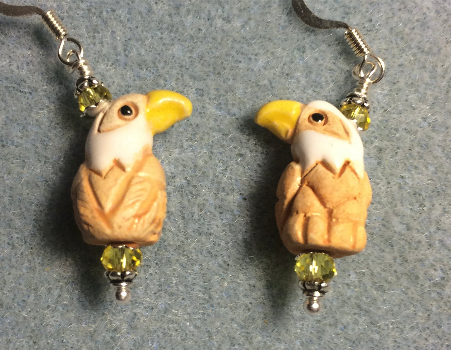Small tan, yellow, and white ceramic eagle bead earrings adorned with yellow Chinese crystal beads.