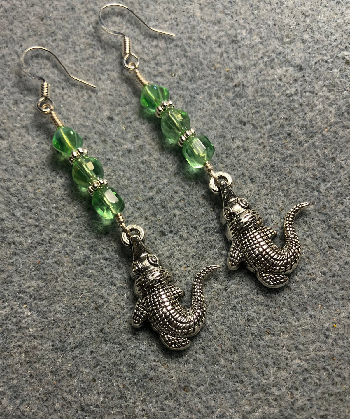 Silver alligator charm earrings adorned with light green Czech glass beads