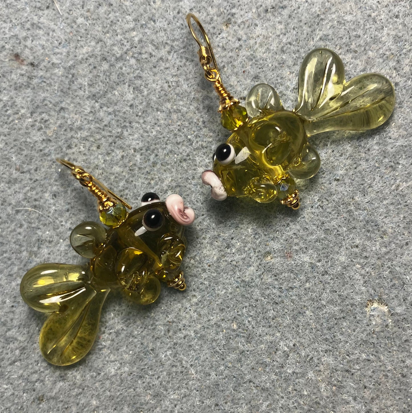 Translucent olive green lamp work fish bead earrings adorned with olive green Chinese crystal beads.