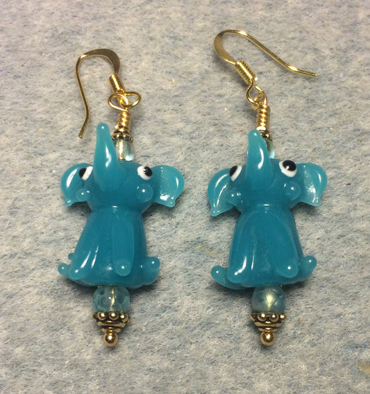 Opaque dark turquoise lamp work sitting elephant bead earrings adorned with dark turquoise Czech glass beads.
