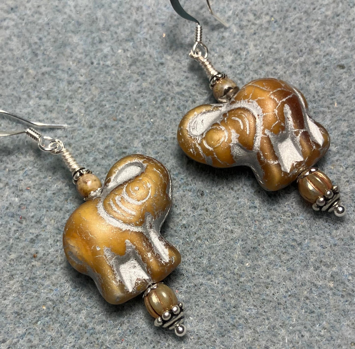 Beige (with silver inlay) Czech glass elephant bead earrings adorned with beige Czech glass beads.