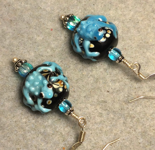 Black and turquoise lamp work frog bead earrings adorned with turquoise Czech glass beads.