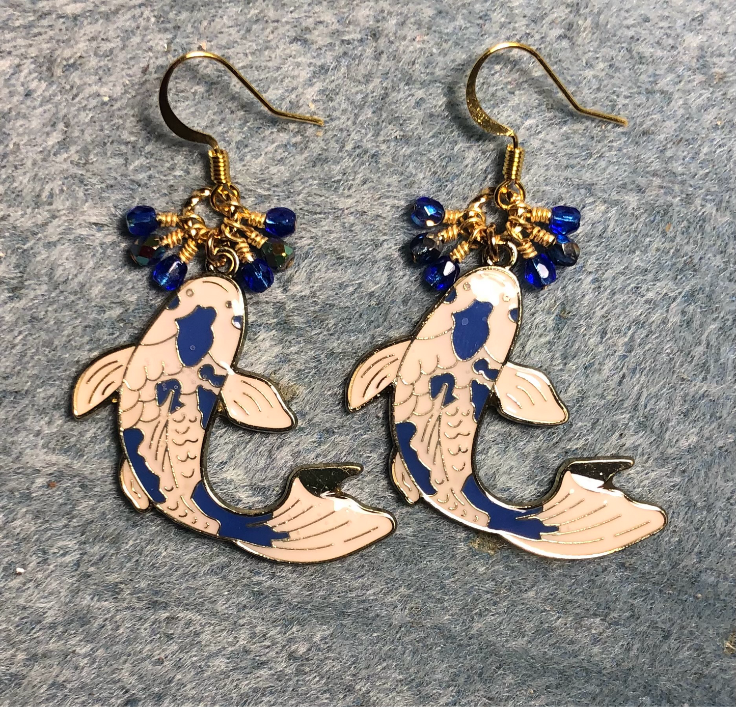 Large blue and white enamel koi charm earrings adorned with small dangling dark blue Czech glass beads.
