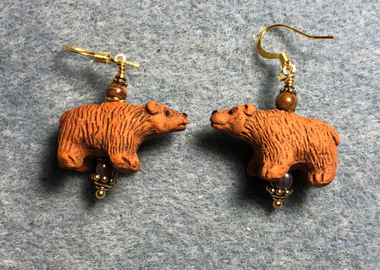 Orange brown ceramic bear bead earrings adorned with orange Czech glass beads.