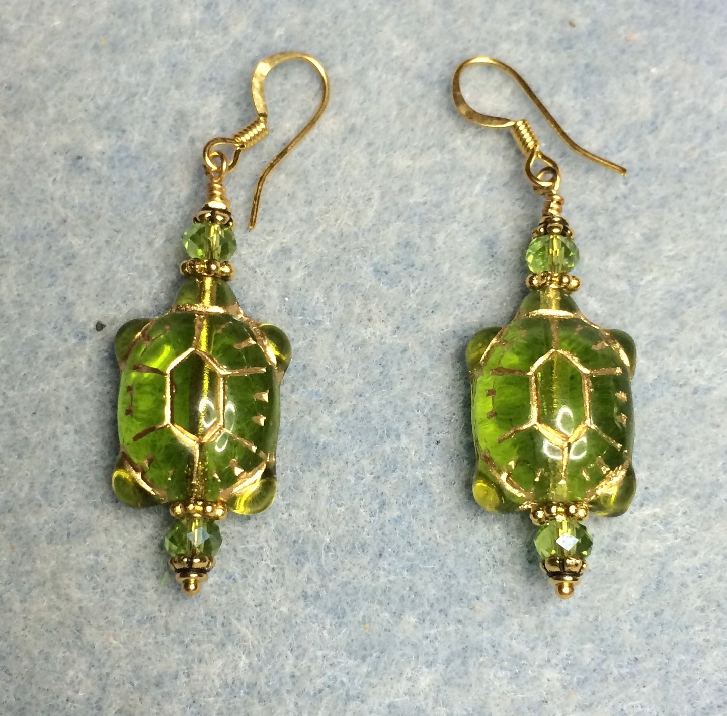 Olive green (with gold inlay) Czech glass turtle bead earrings adorned with olive green Chinese crystal beads.