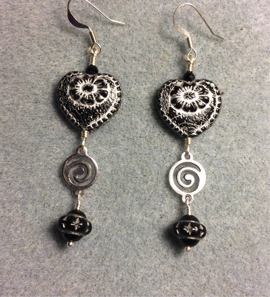 Opaque black (with silver inlay) Czech glass heart bead earrings adorned with silver swirly links and black Czech glass Saturn beads.