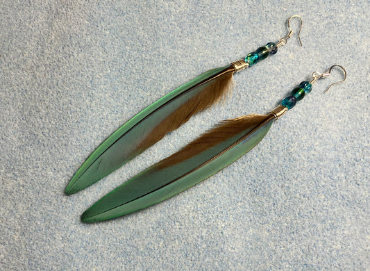 Long slender turquoise blue and gold feather earrings adorned with turquoise Czech glass beads.