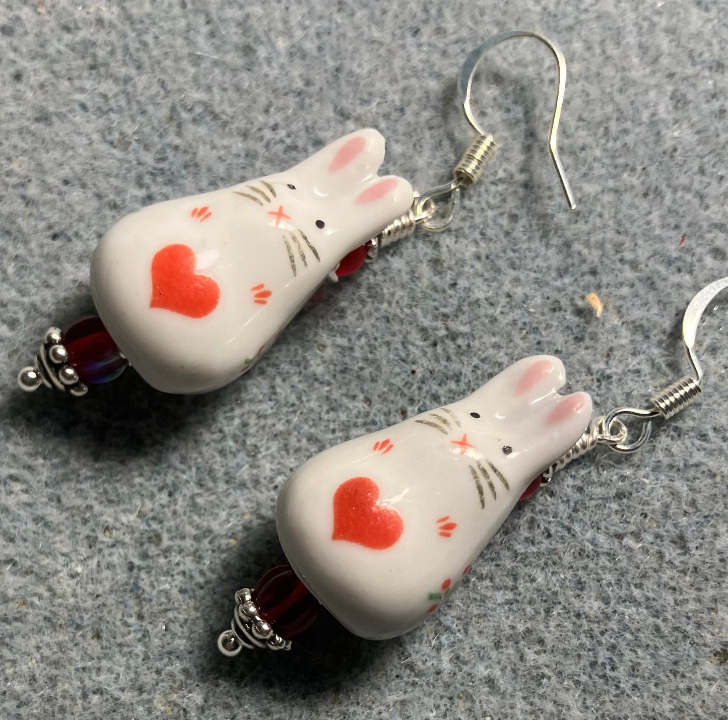 White and red ceramic bunny rabbit bead earrings adorned with red Czech glass beads.