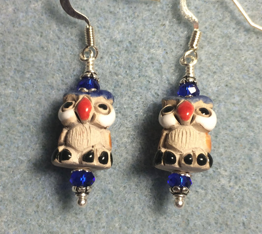 Small tan, red, and dark blue ceramic owl bead earrings adorned with dark blue Chinese crystal beads.