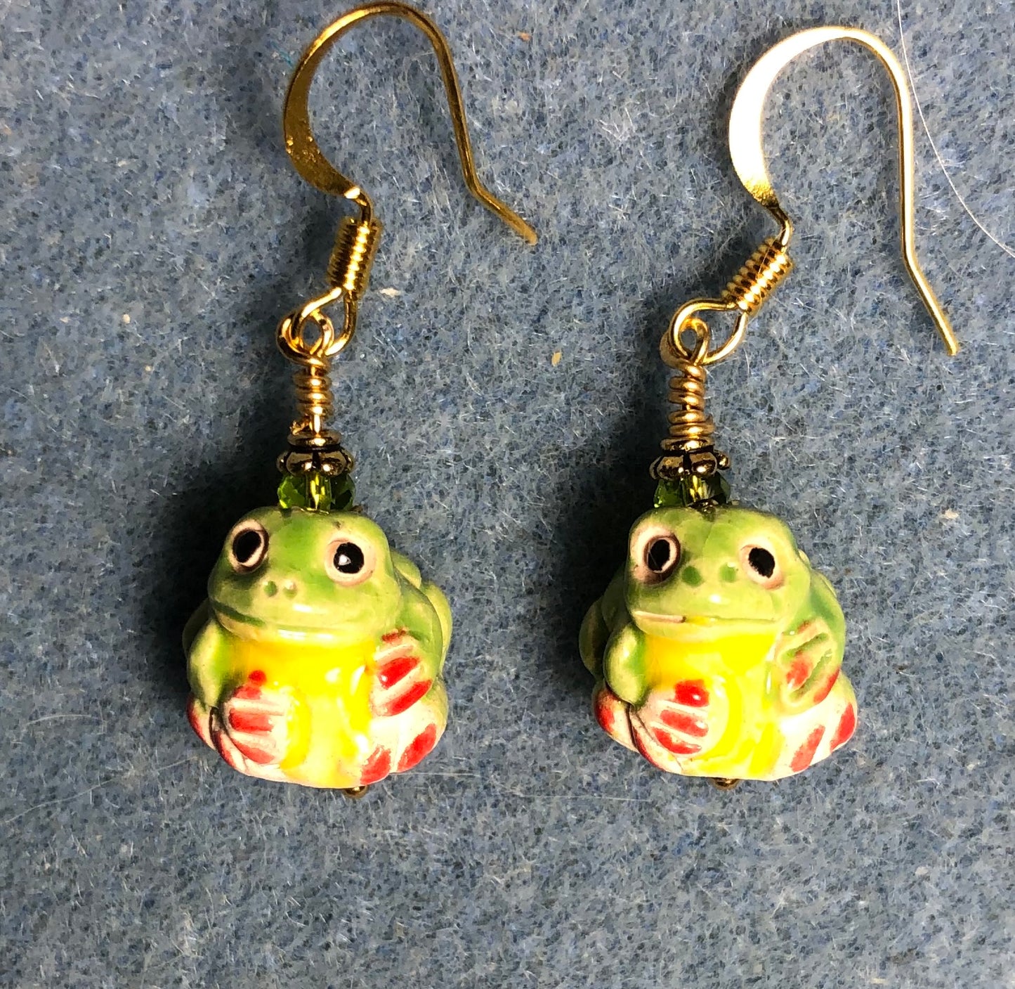 Small green, yellow, and red ceramic frog bead earrings adorned with olive green Chinese crystal beads.