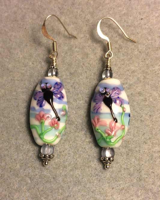 Purple, pink, and blue lamp work dragonfly bead earrings adorned with light blue Czech glass beads.