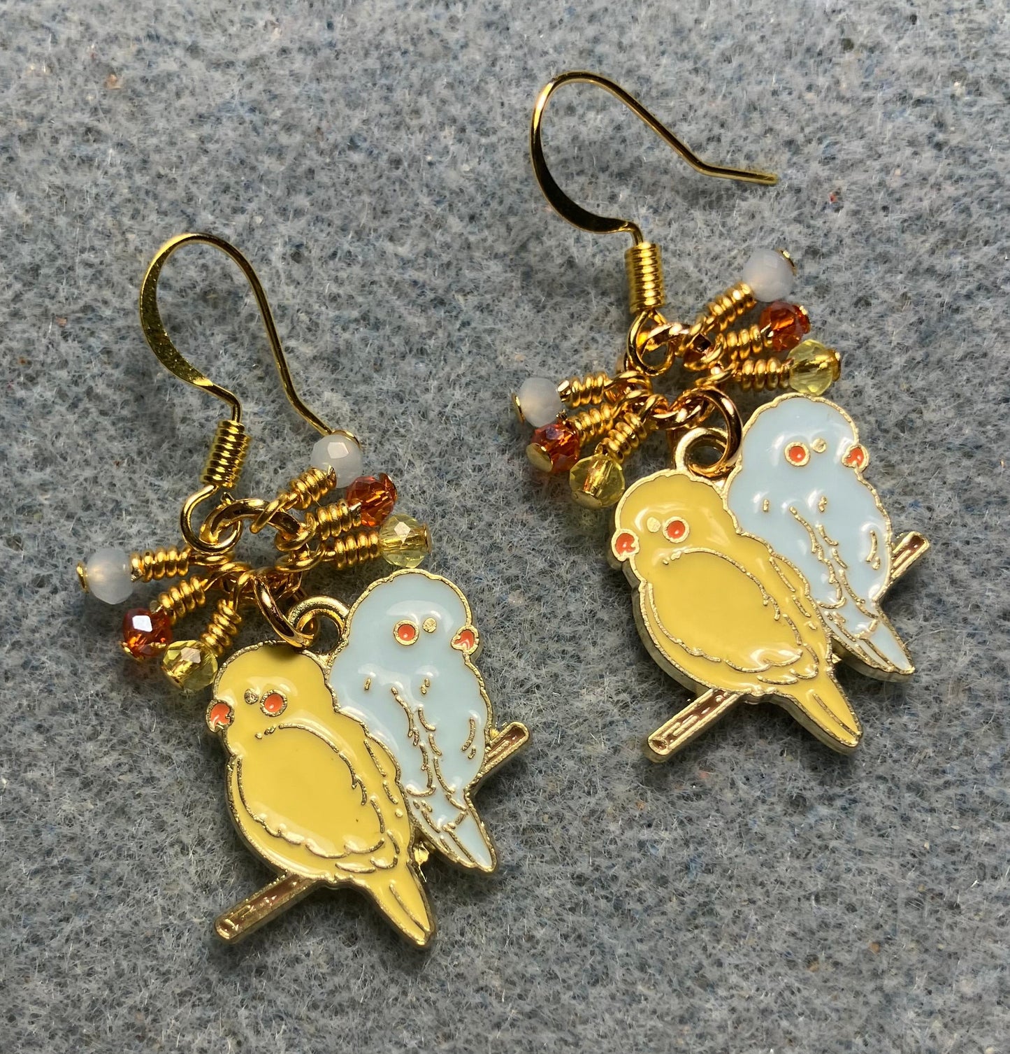 Yellow and light blue enamel pair of lovebird charm earrings adorned with tiny dangling yellow, light blue, and orange Chinese crystal beads.