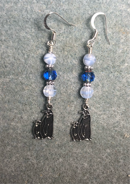 Silver mother and baby penguin charm earrings adorned with white and blue Czech glass beads.