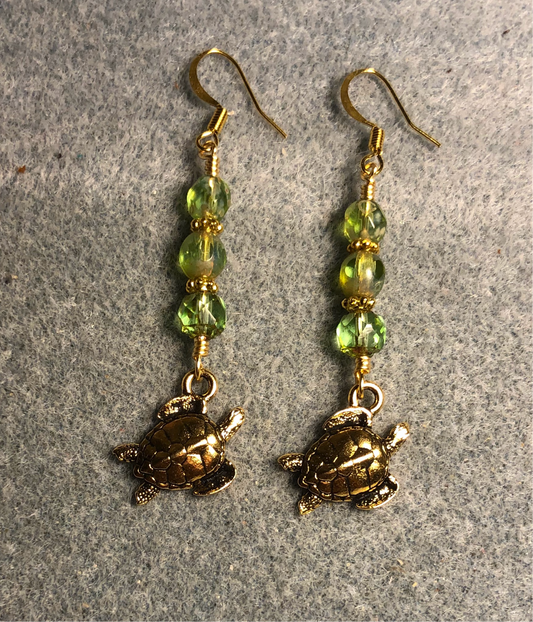 Gold Tierracast sea turtle charm earrings adorned with light green Czech glass beads