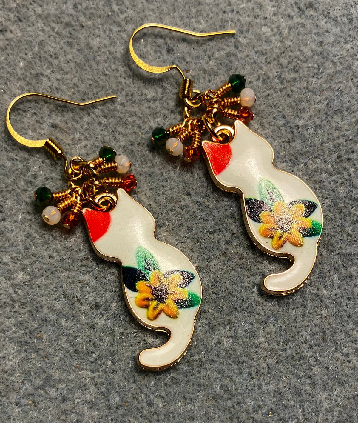 White, orange, amber, and green enamel cat charm earrings adorned with tiny dangling white, orange, and green Chinese crystal beads.