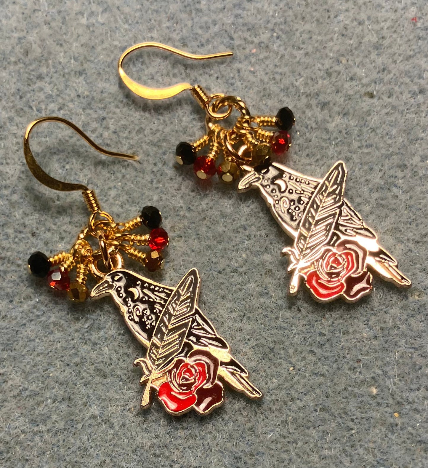 Black, red, and gold enamel raven charm earrings adorned with tiny dangling black, red, and gold Chinese crystal beads.