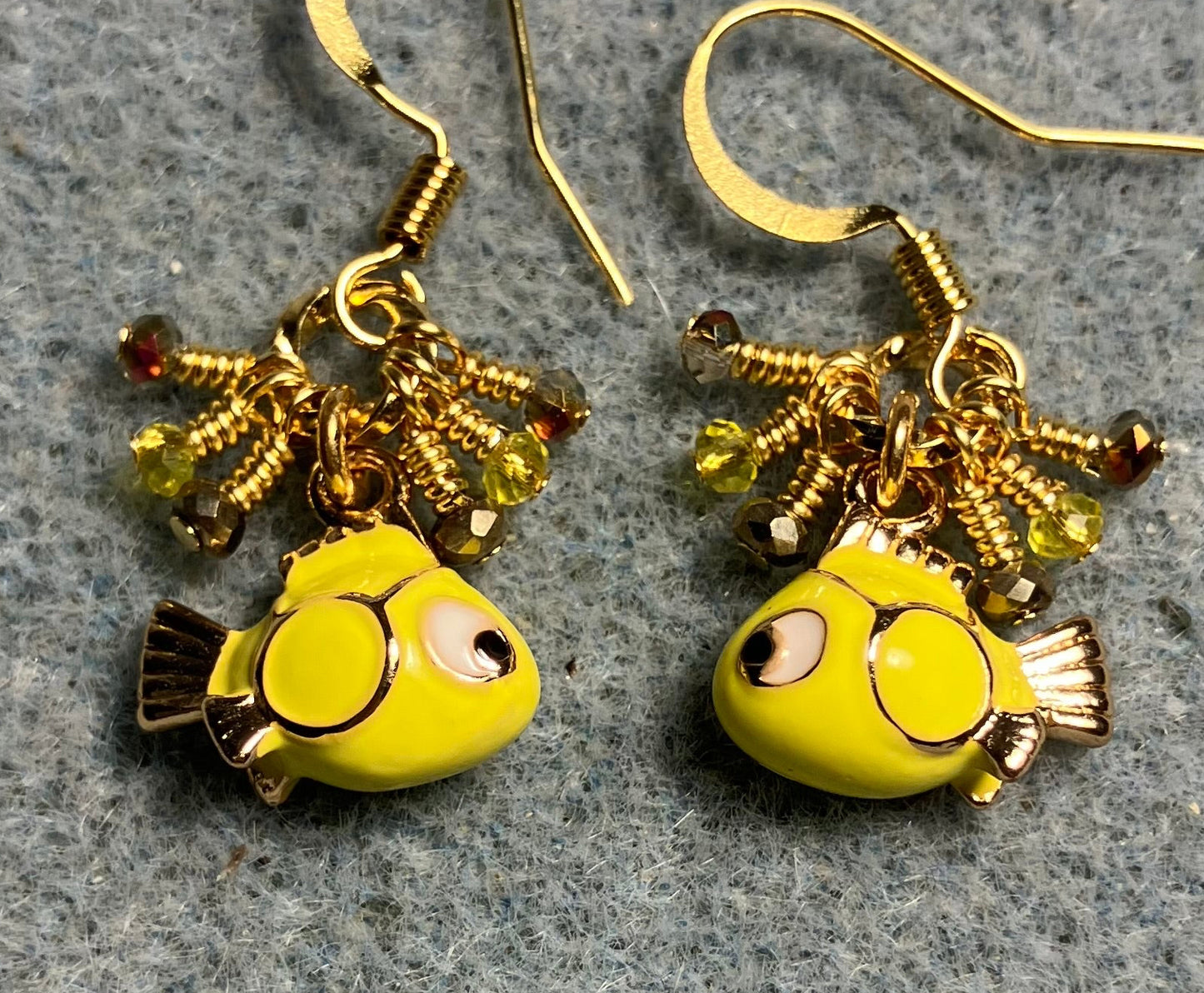 Tiny yellow and black enamel fish charm earrings adorned with tiny dangling yellow and gold Chinese crystal beads.