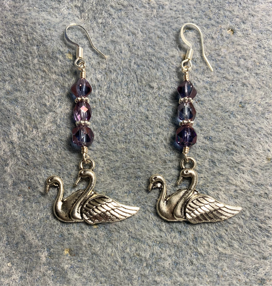 Silver swan charm earrings adorned with violet Czech glass beads.