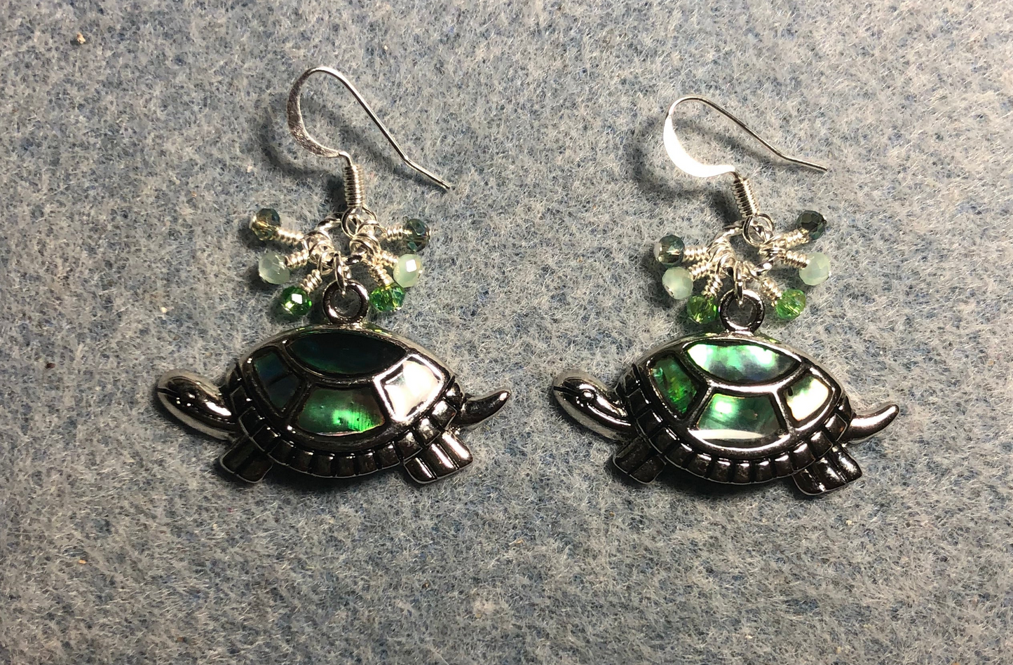 Silver and abalone turtle charm earrings adorned with small dangling light green and silver Chinese crystal beads.