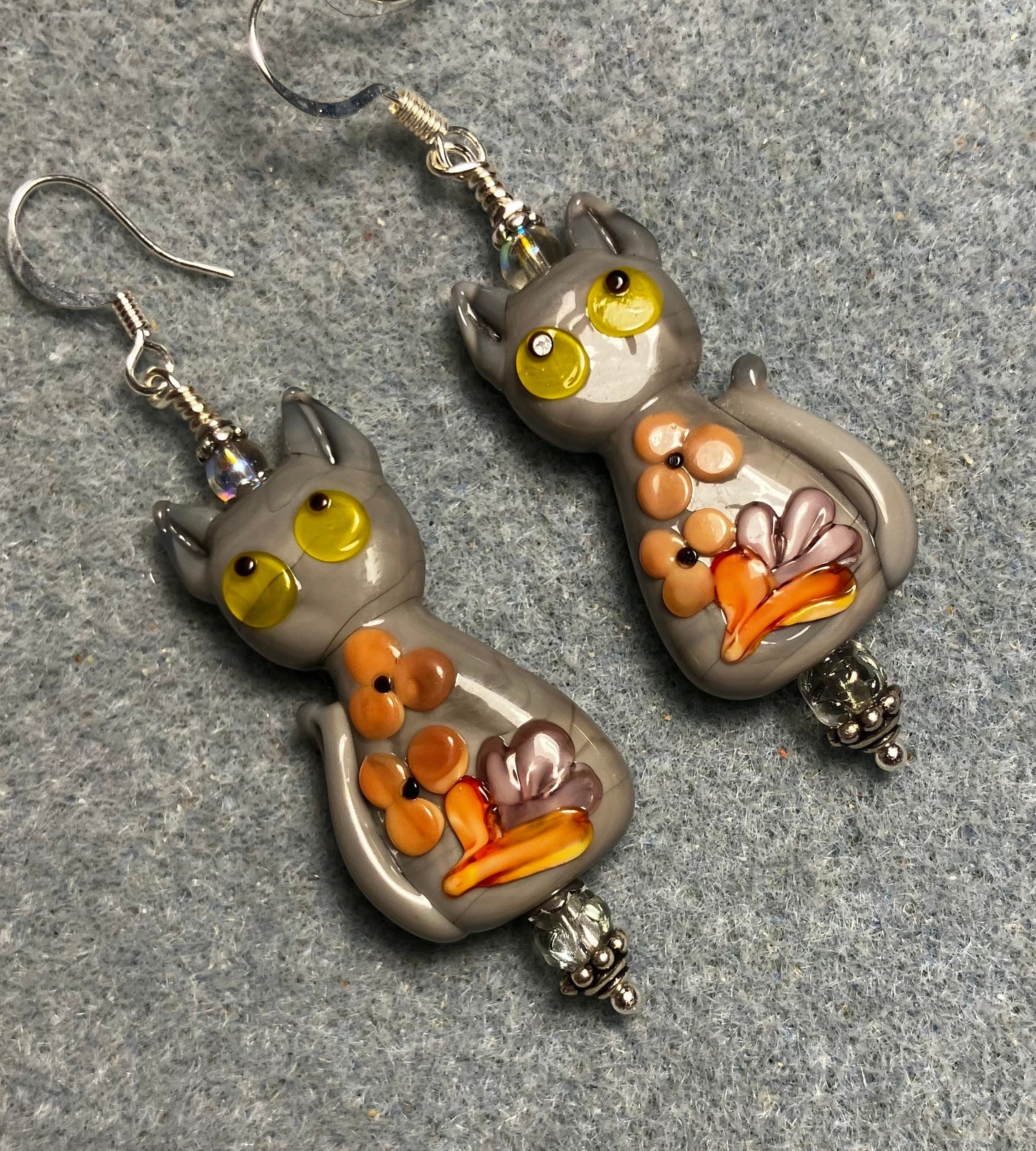 Large gray, orange, and yellow lamp work cat bead earrings adorned with gray Czech glass beads.