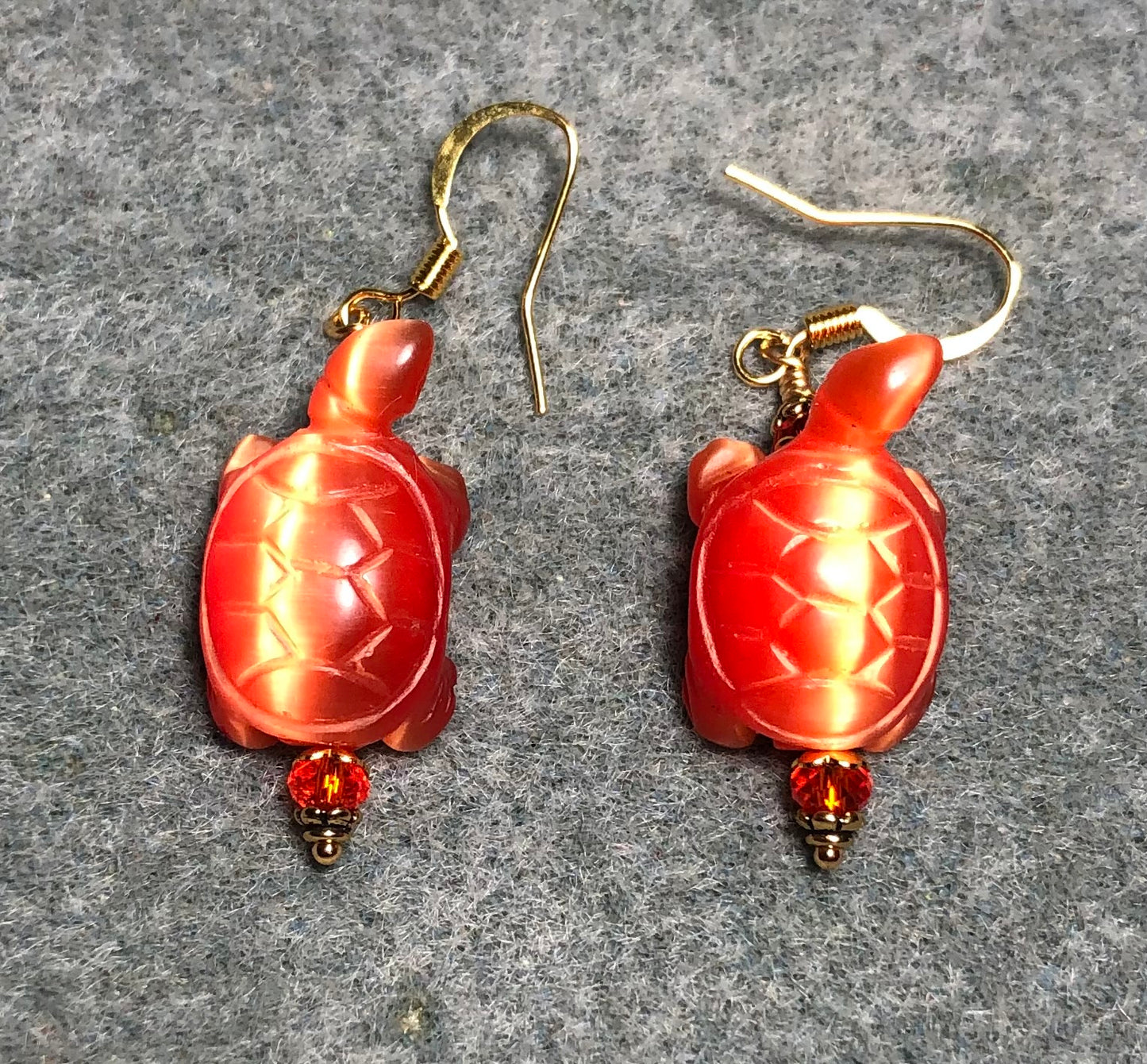 Orange fiber optic (cat’s eye) turtle bead earrings adorned with orange Chinese crystal beads.