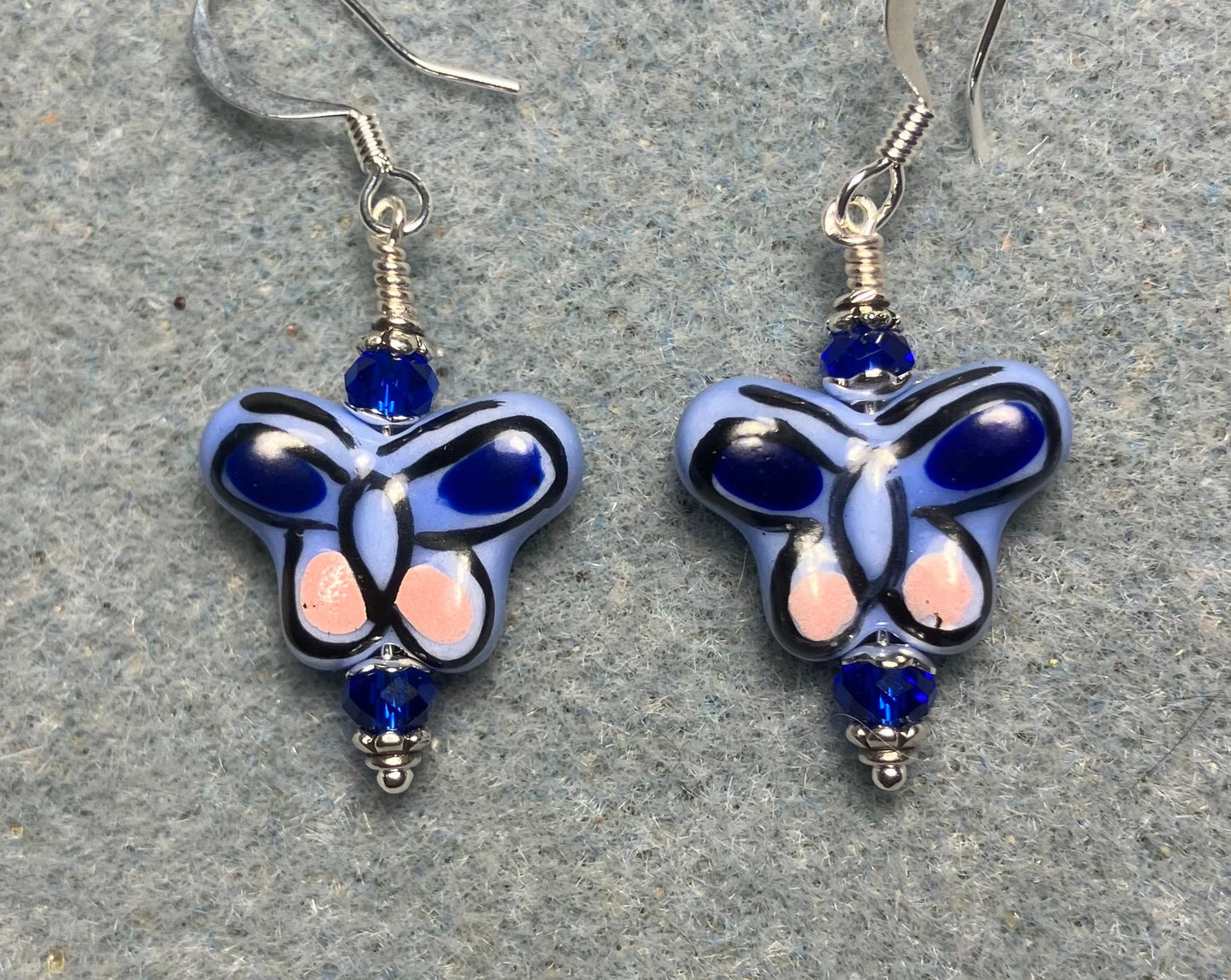 Blue and pink ceramic butterfly bead earrings adorned with dark blue Chinese crystal beads.