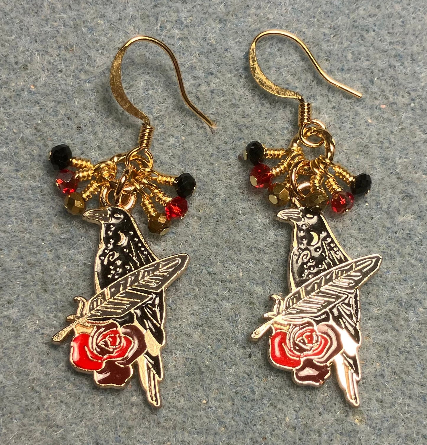 Black, red, and gold enamel raven charm earrings adorned with tiny dangling black, red, and gold Chinese crystal beads.