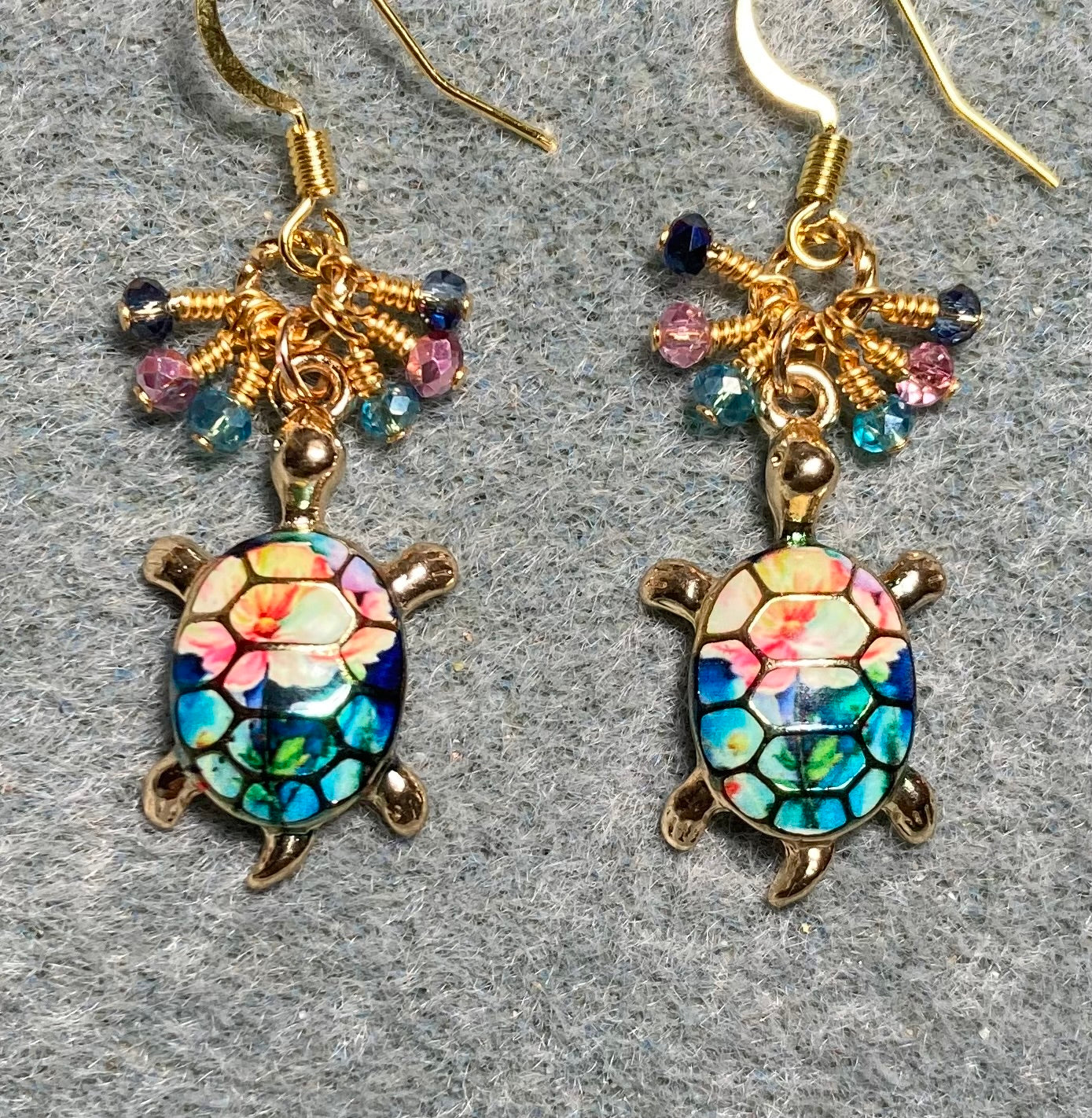 Turquoise, pink, and dark blue enamel turtle charm earrings adorned with tiny dangling turquoise, pink, and dark blue Chinese crystal beads.