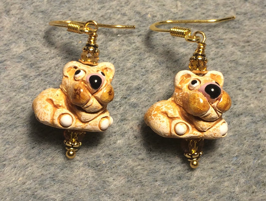 Small tan and brown ceramic lion bead earrings adorned with amber Chinese crystal beads.