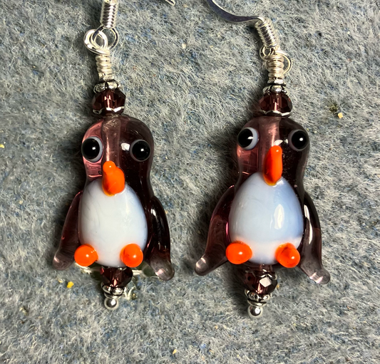 Translucent violet and white lamp work penguin bead earrings adorned with violet Chinese crystal beads.