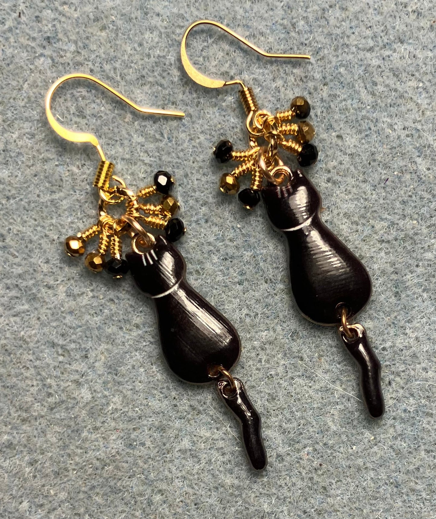 Black and gold enamel cat charm earrings adorned with tiny dangling black and gold Chinese crystal beads.