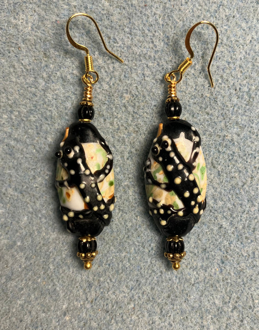 Black and yellow lamp work tiger salamander bead earrings adorned with black Czech glass beads.