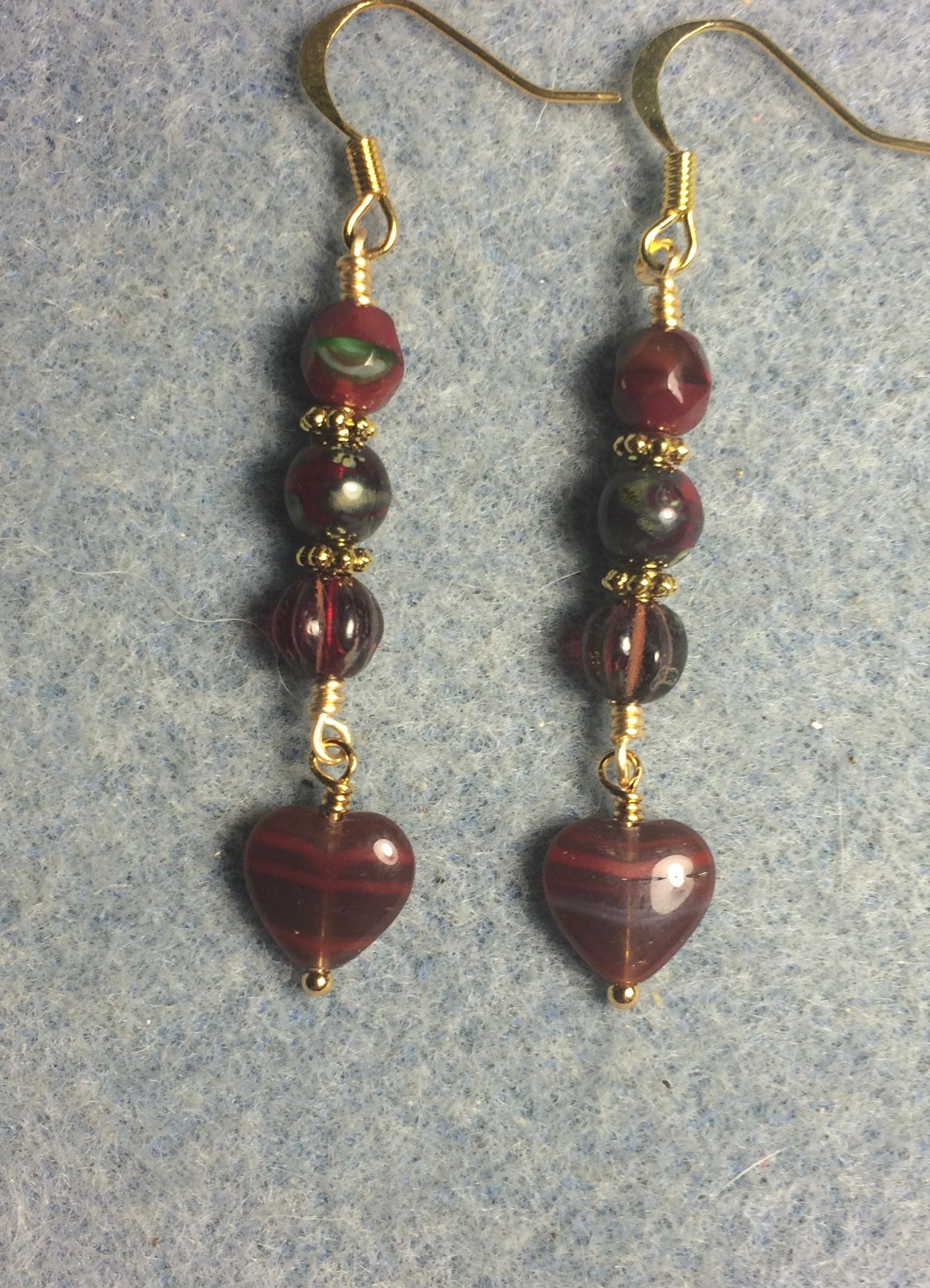 Small ruby red Picasso Czech glass heart bead earrings adorned with ruby red Picasso Czech glass beads.