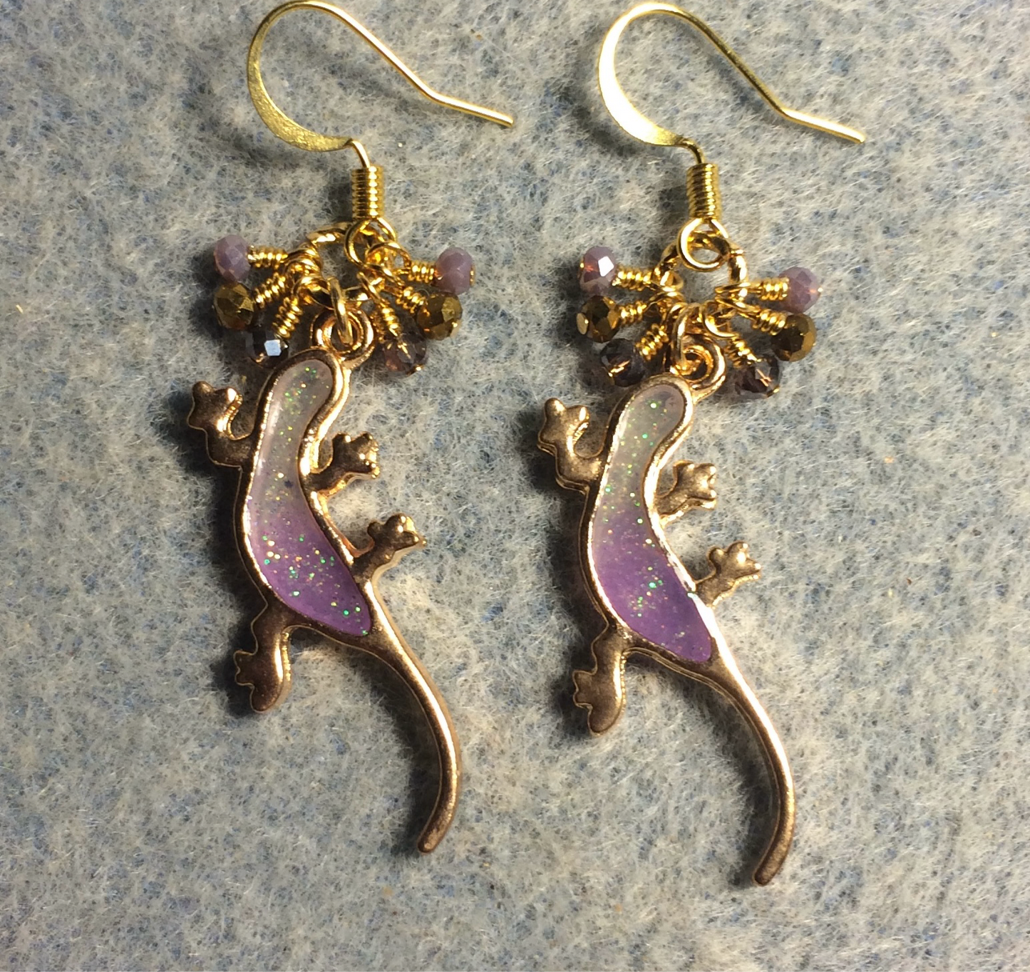 Purple and gold resin lizard charm earrings adorned with tiny dangling purple and gold Chinese crystal beads.