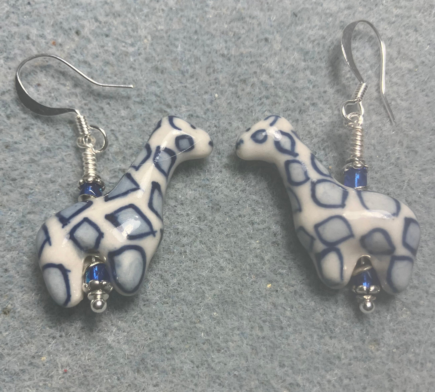 Dark blue and white ceramic spotted giraffe bead earrings adorned with small dark blue Czech glass beads.