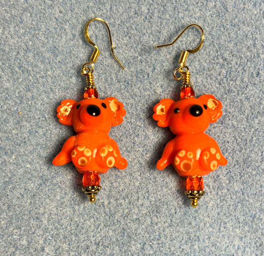 Large orange lamp work koala bear bead earrings adorned with orange Chinese crystal beads.