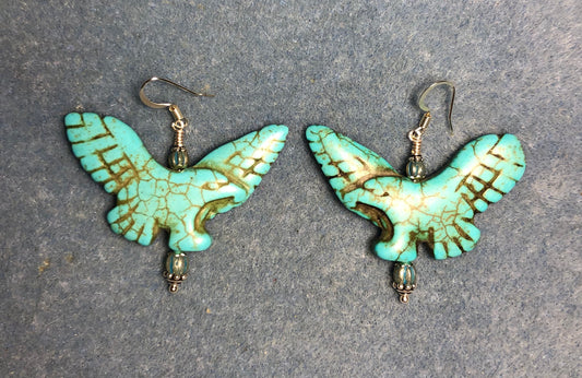 Large turquoise howlite gemstone flying eagle bead earrings adorned with turquoise Chinese crystal beads.