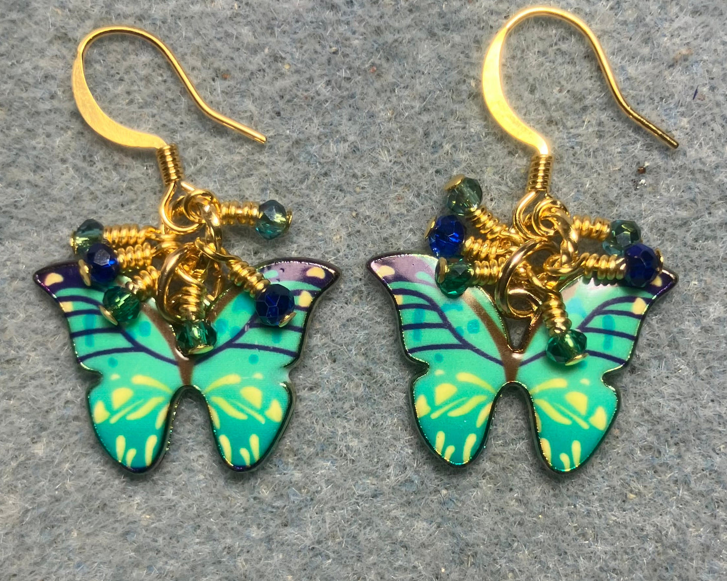 Green, aqua, and blue enamel butterfly charm earrings adorned with tiny dangling green, aqua, and blue Chinese crystal beads.