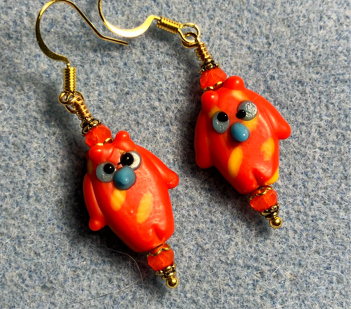 Orange red lamp work owl bead earrings adorned with orange red Chinese crystal beads.